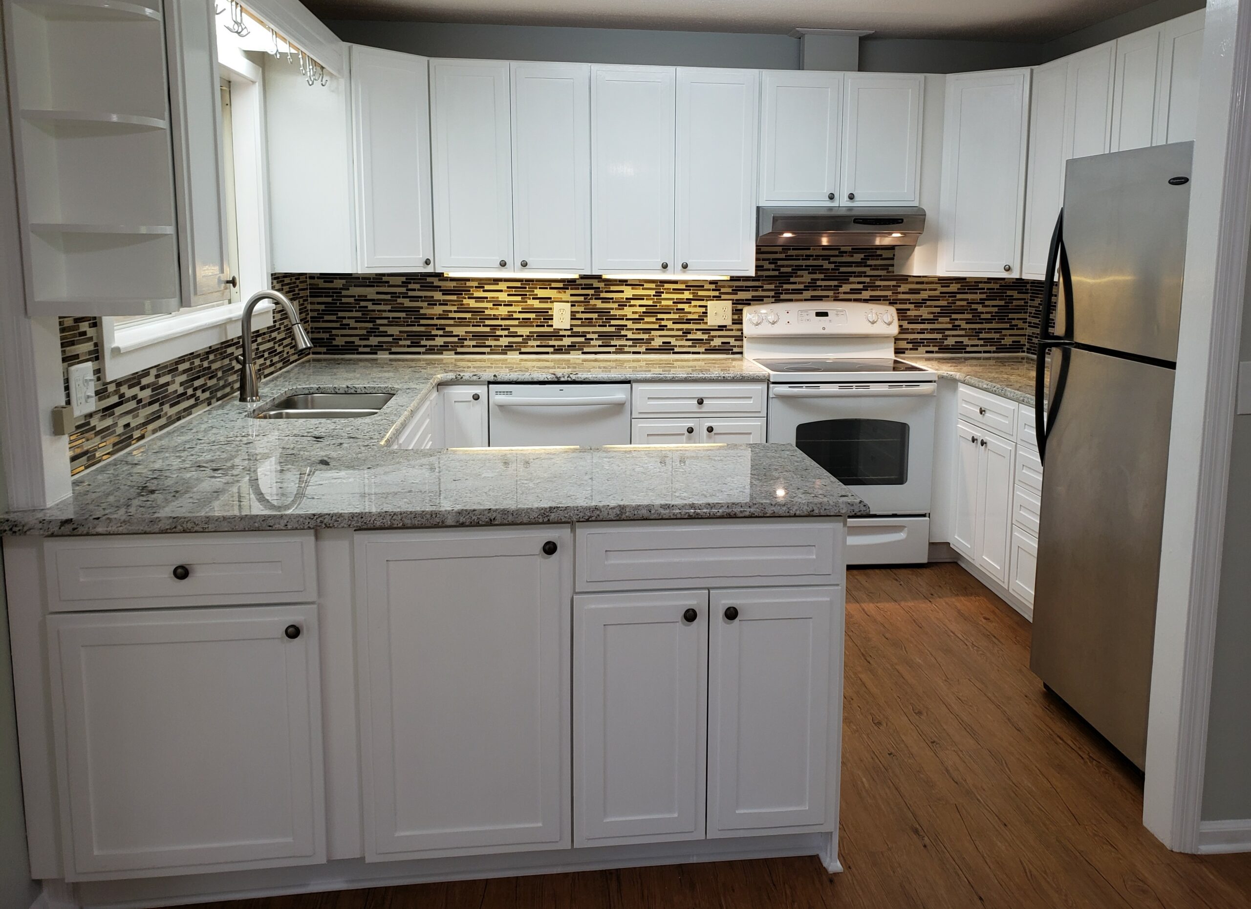 Prepare for showings by clearing any surface. This photos shows a kitchen with bare counters and all lights on. This is best staging you can give your kitchen counters.