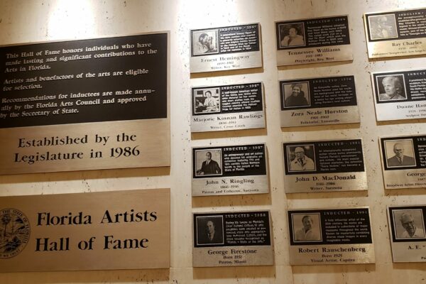 Photo shows plaques on the wall for Florida's artists of the year with a photo and brief bio.